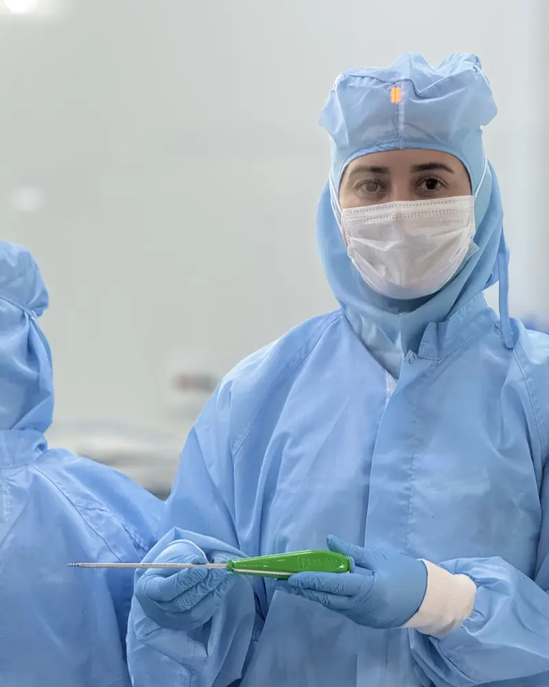 Sartori team member in clean-room garments holding an instrument